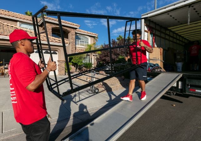 Two movers loading furniture into truck.