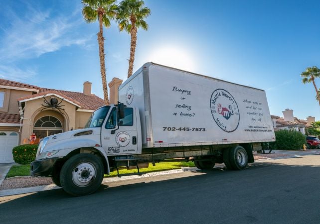 Moving truck parked in residential neighborhood street.