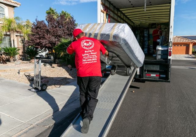 Mover loading mattress onto truck ramp.